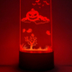Foto de un metacrilato grabado con motivos de Halloween sobre una peana con luces de colores que ilumina el centro del metacrilato